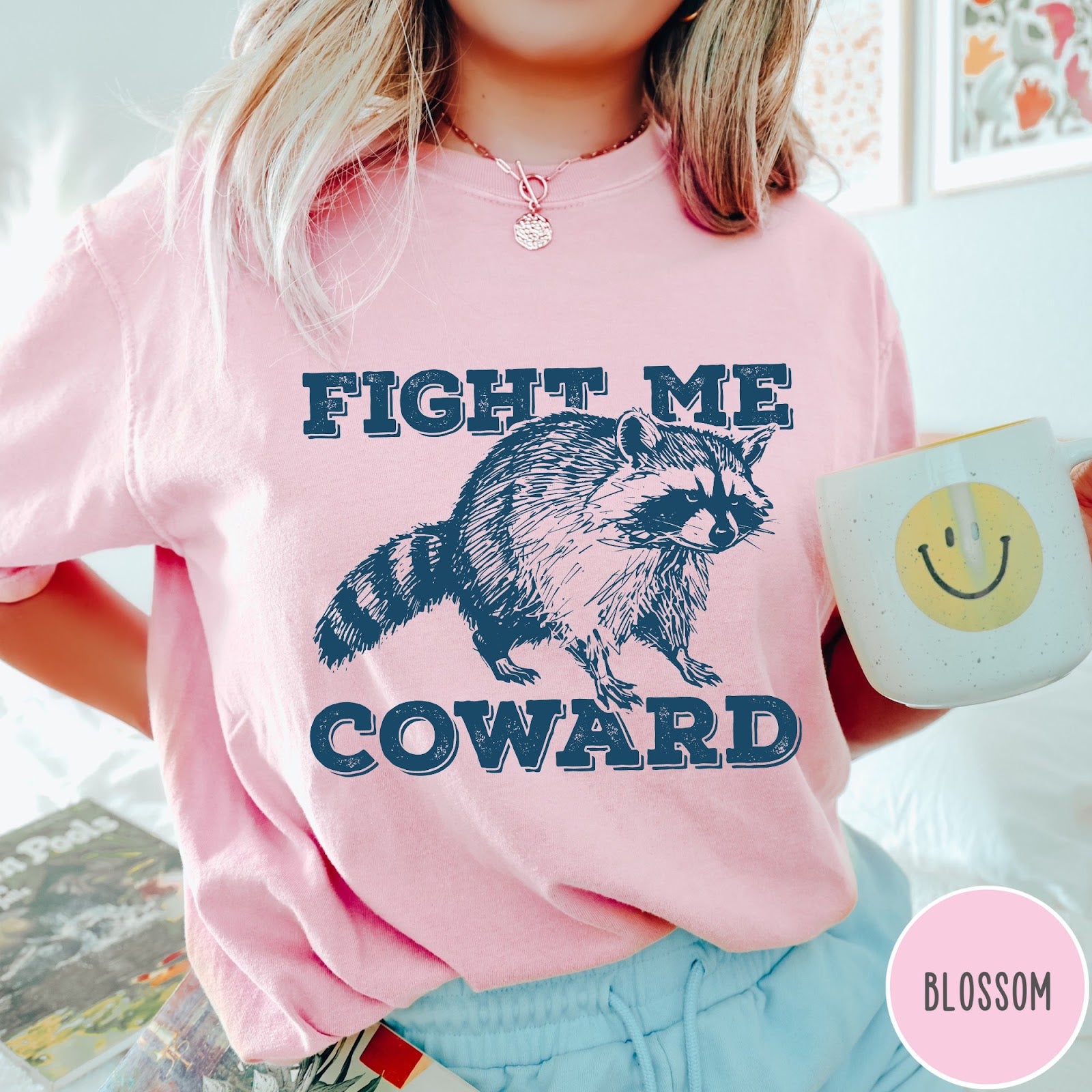 Comfort Colors tee in Blossom featuring screen printed raccoon graphic with Fight Me Coward text design