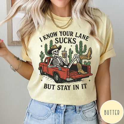 Comfort Colors tee in Butter featuring western skeleton design with cowboy hat and boots in truck bed