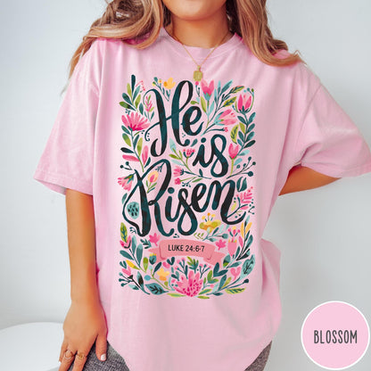 Comfort Colors tee in Blossom featuring Easter religious floral graphic with He is Risen and Luke 24:6-7 text
