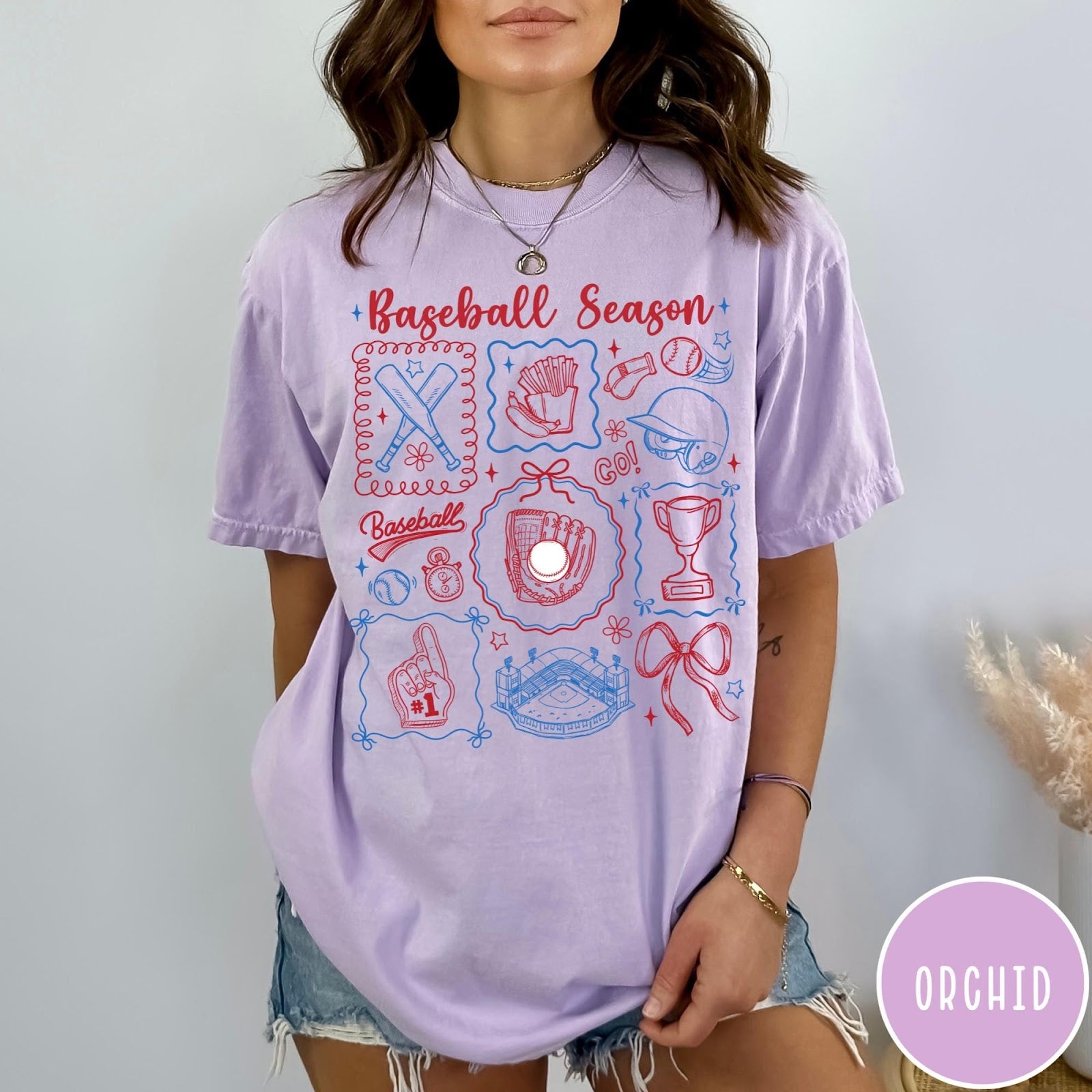 Comfort Colors tee in Orchid featuring baseball icons including bats, a glove, stadium, and trophy graphic design