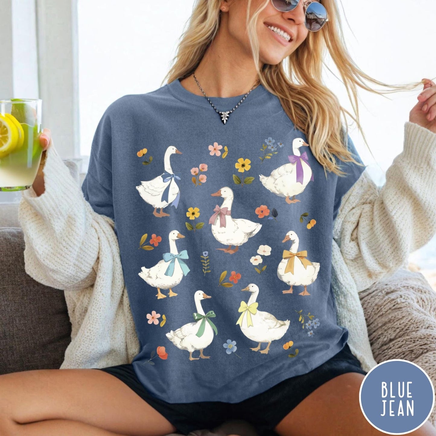 Comfort Colors tee in Blue Jean featuring vintage style graphic of several white geese wearing colorful bows and flowers