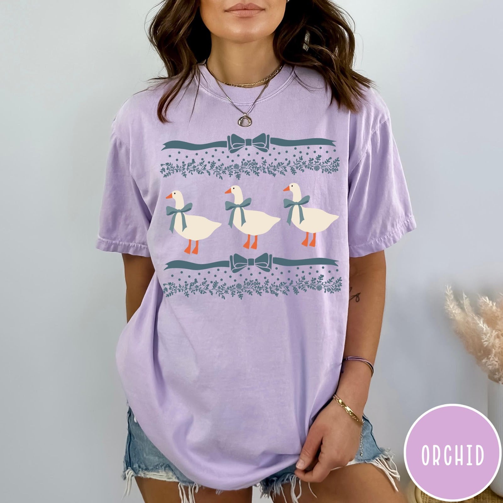 Comfort Colors tee in Orchid featuring vintage style graphic with three geese wearing blue ribbons and floral borders