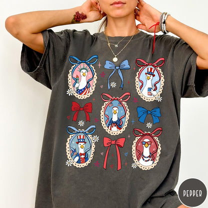 Comfort Colors tee in Pepper featuring coquette style patriotic goose graphic with bows and floral accents