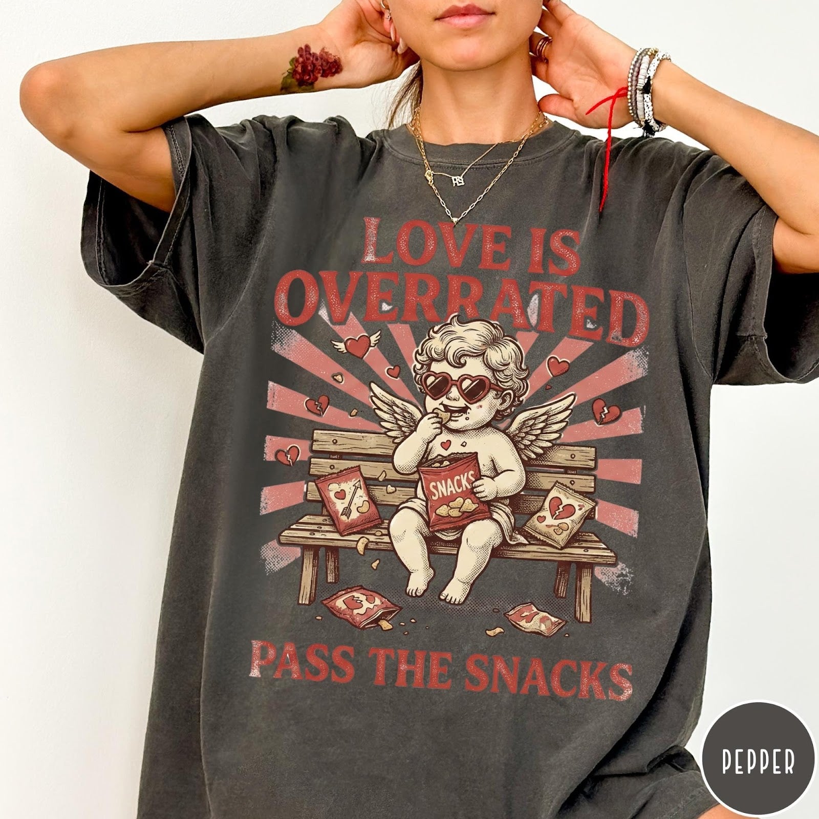 Comfort Colors tee in Pepper featuring vintage style graphic of a cherub eating snacks on a bench