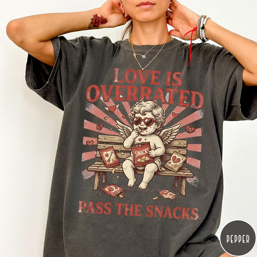 Comfort Colors tee in Pepper featuring vintage style graphic of a cherub eating snacks on a bench