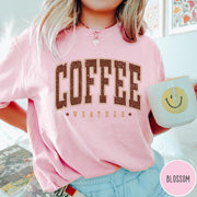 Comfort Colors tee in Blossom featuring collegiate style Coffee Weather graphic with distressed brown text and stars