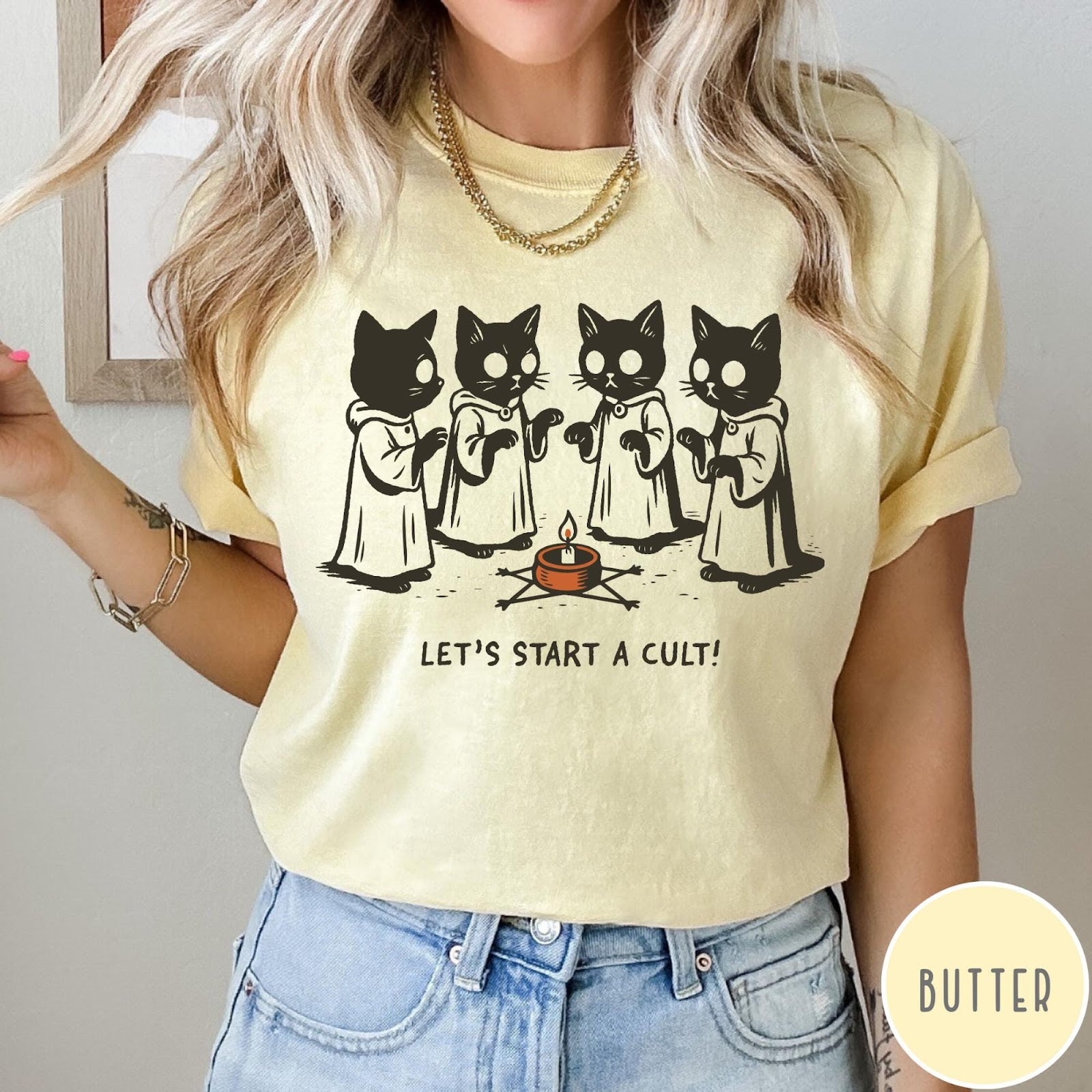Comfort Colors tee in Butter featuring illustrated style graphic of four cats in robes around a candle