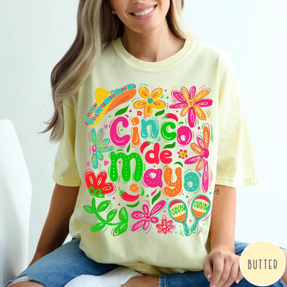 Comfort Colors tee in Butter featuring festive Cinco de Mayo graphic with sombrero, maracas, and colorful flowers