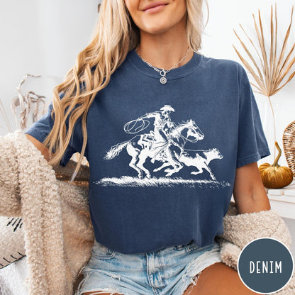 Comfort Colors tee in Denim featuring western style graphic of a cowboy roping a calf on horseback
