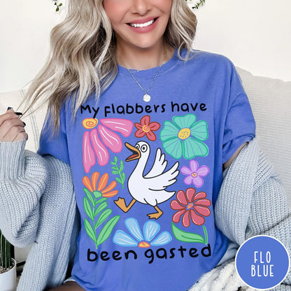Comfort Colors tee in Flo Blue featuring playful cartoon style graphic of a goose surrounded by colorful flowers