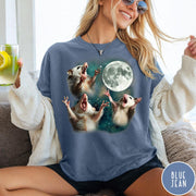 Comfort Colors tee in Blue Jean featuring vintage graphic style with three screaming possums reaching for the moon