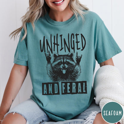 Comfort Colors tee in Seafoam featuring graphic style raccoon with tongue out and rock and roll hands