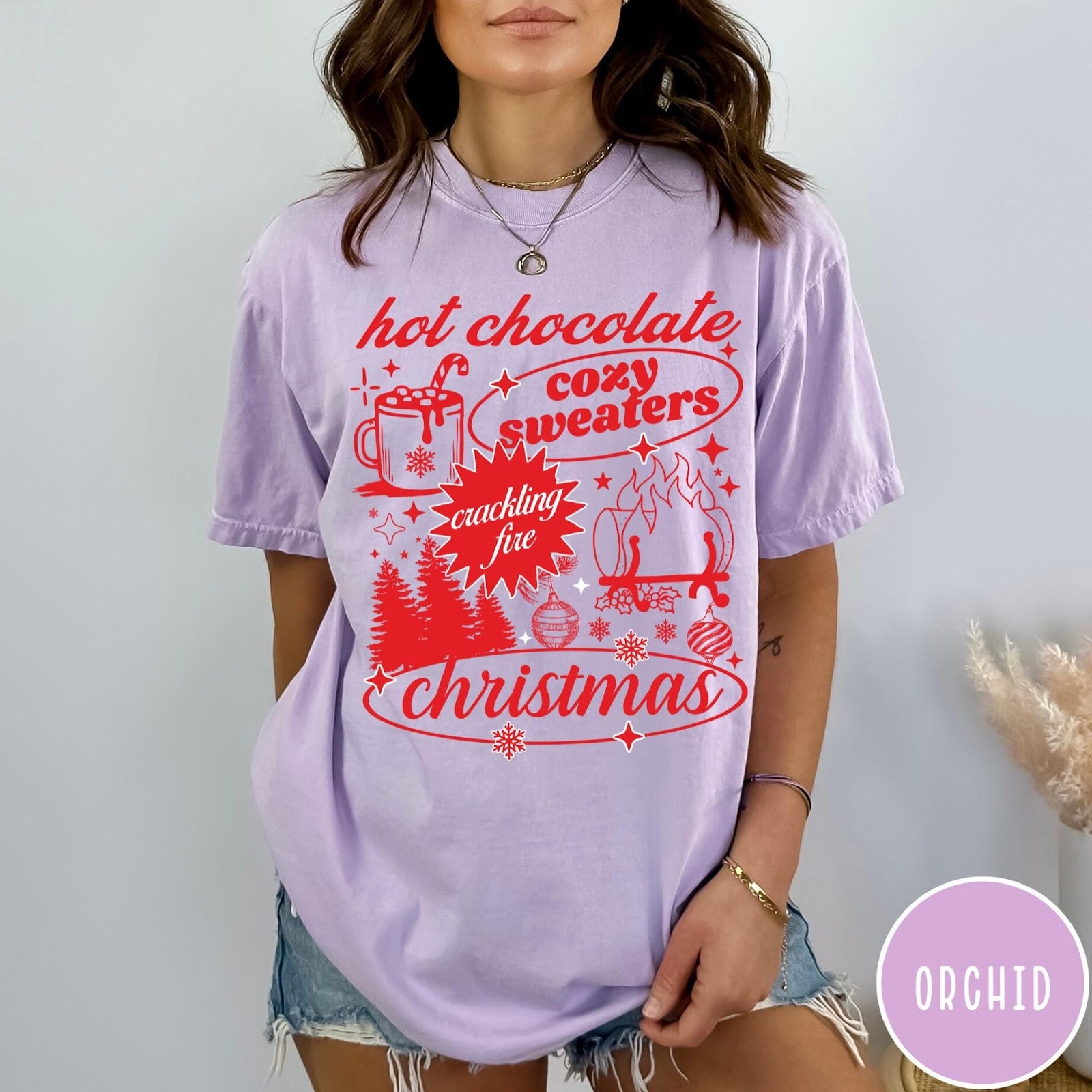 Comfort Colors tee in Orchid featuring holiday graphic design with hot chocolate, fire, and Christmas trees