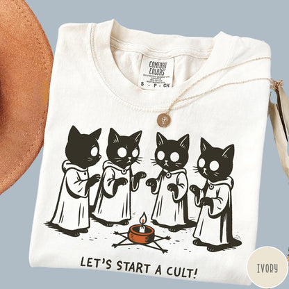 Comfort Colors tee in Ivory featuring illustrated style graphic of four cats in robes around a candle