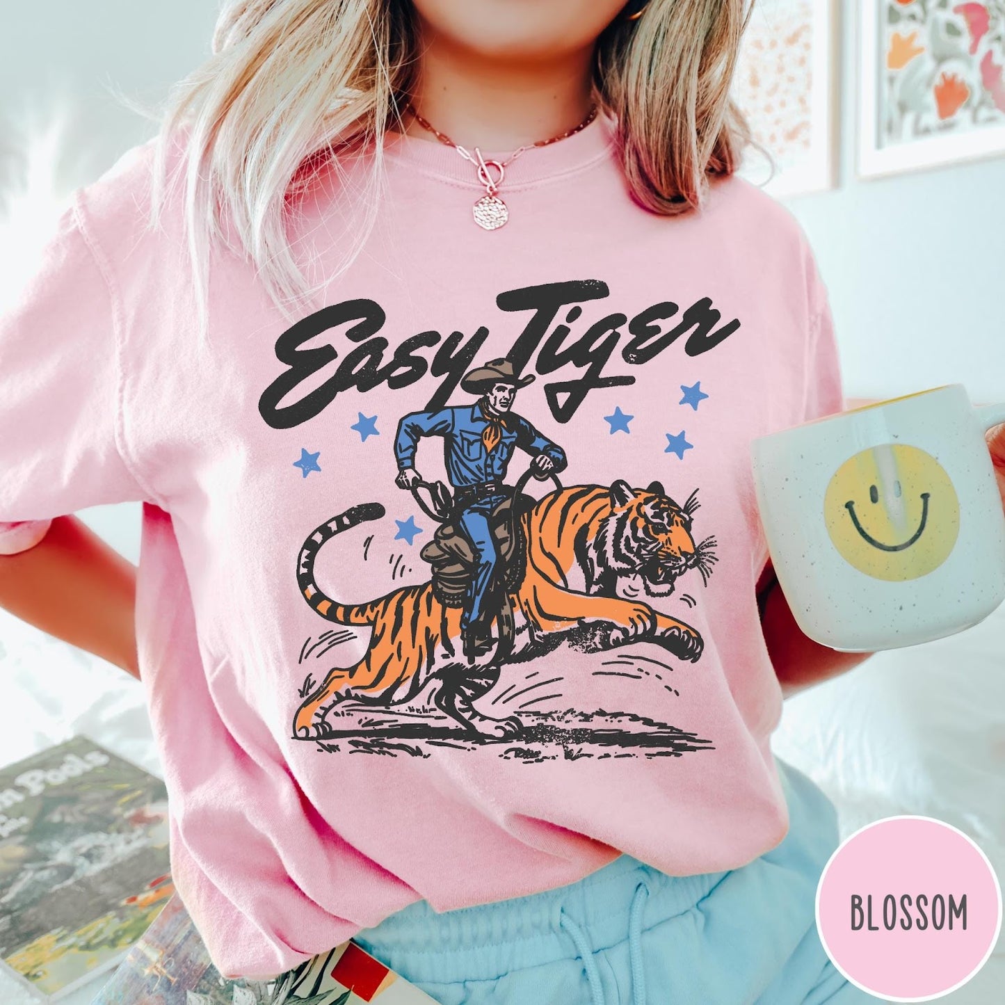 Comfort Colors tee in Blossom featuring western graphic style cowboy riding a tiger with blue stars