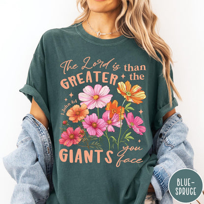 Comfort Colors tee in Blue Spruce featuring floral Bible verse graphic design with 1 John 4:4 scripture text
