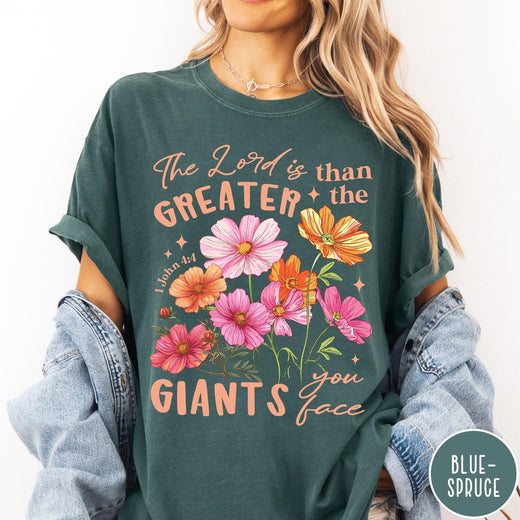 Comfort Colors tee in Blue Spruce featuring floral Bible verse graphic design with 1 John 4:4 scripture text
