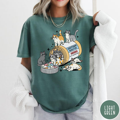 Comfort Colors tee in Light Green featuring graphic illustration of cats spilling out of a serotonin booster bottle