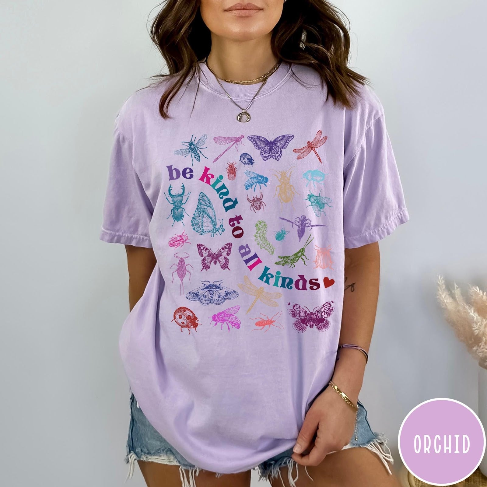Comfort Colors tee in Orchid featuring insect and butterfly graphic with text be kind to all kinds