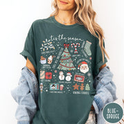 Comfort Colors tee in Blue Spruce featuring festive holiday graphic with Christmas icons like a tree and cocoa
