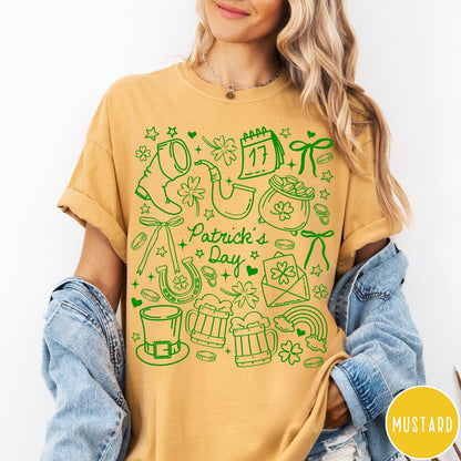 Comfort Colors tee in Mustard featuring line art style St. Patrick's Day icons including shamrocks and leprechaun hat