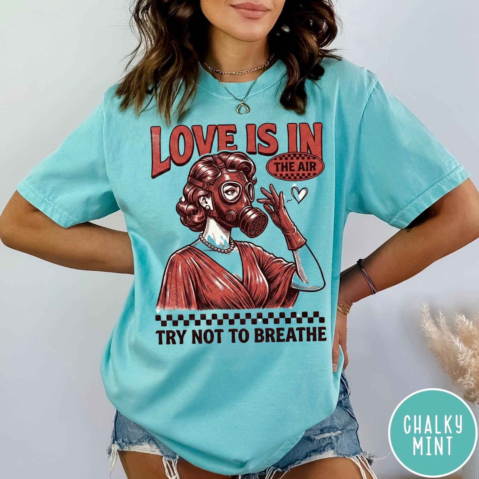 Comfort Colors tee in Chalky Mint featuring retro graphic design of a woman wearing a gas mask