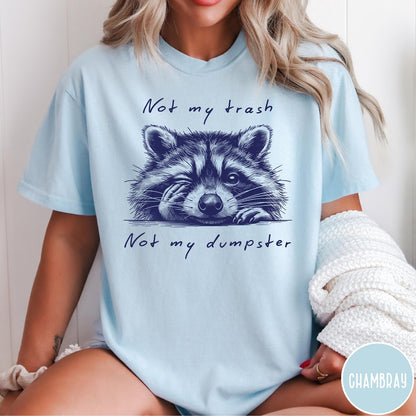 Comfort Colors tee in Chambray featuring illustrated style graphic of a winking raccoon with text not my trash