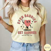 Comfort Colors tee in Butter featuring retro style graphic of a sad heart character with devil horns