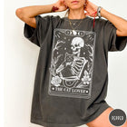 Comfort Colors tee in Pepper featuring tarot style graphic of a skeleton holding a black cat