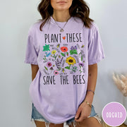 Comfort Colors tee in Orchid featuring botanical garden style graphic with various flowers and bees