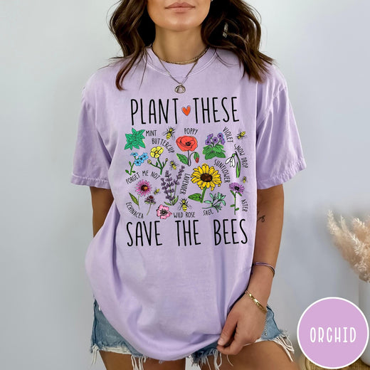 Comfort Colors tee in Orchid featuring botanical garden style graphic with various flowers and bees