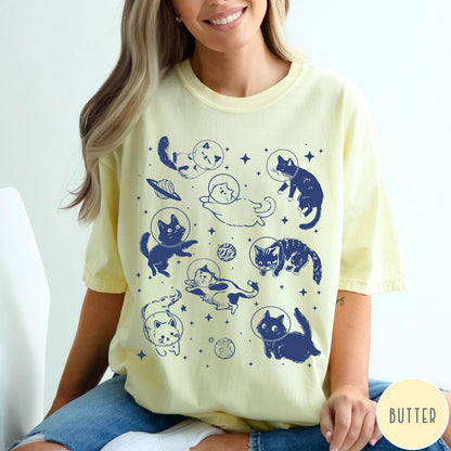 Comfort Colors tee in Butter featuring whimsical space style graphic with multiple cats floating in space helmets