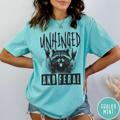 Comfort Colors tee in Chalky Mint featuring graphic style raccoon with tongue out and rock and roll hands