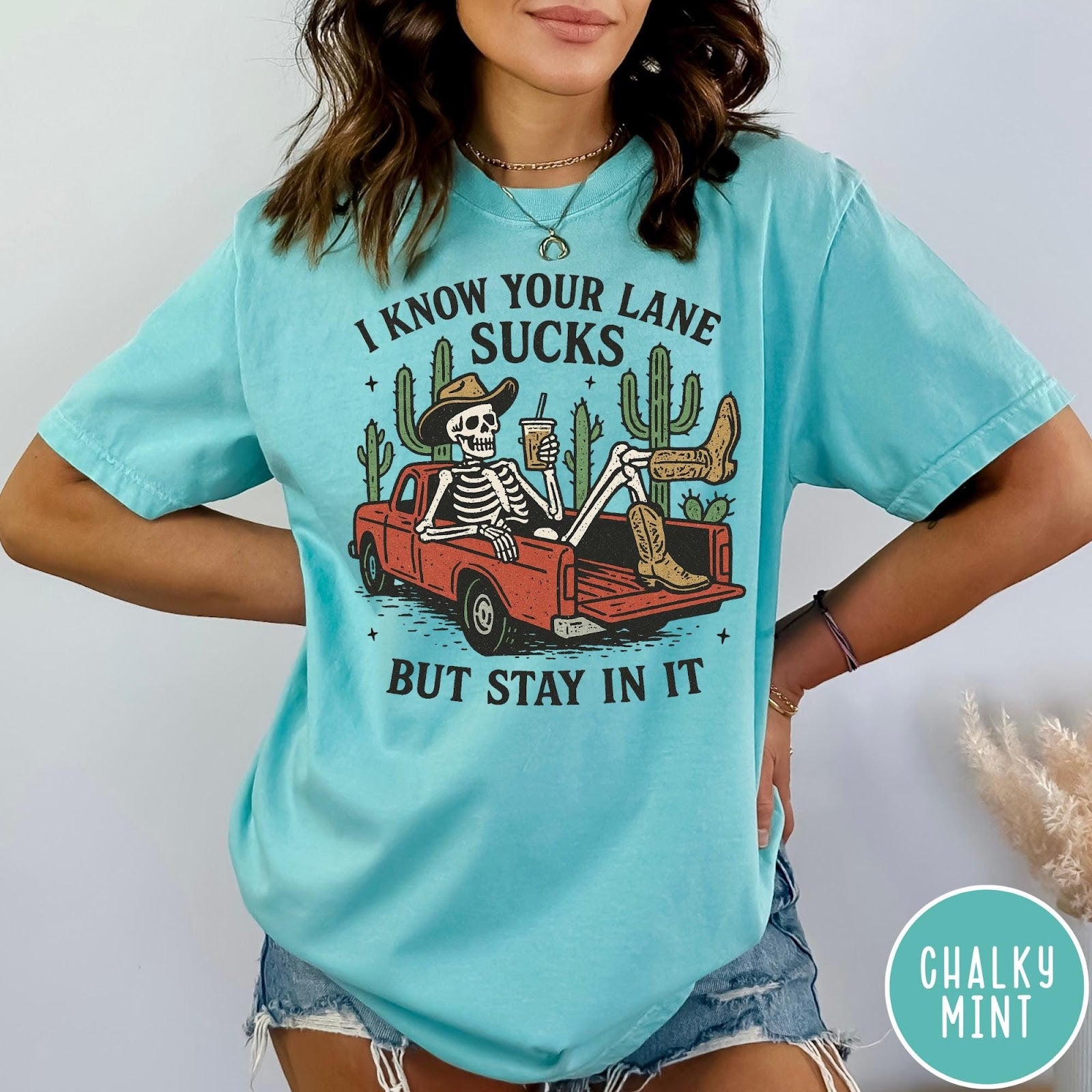 Comfort Colors tee in Chalky Mint featuring western skeleton design with cowboy hat and boots in truck bed