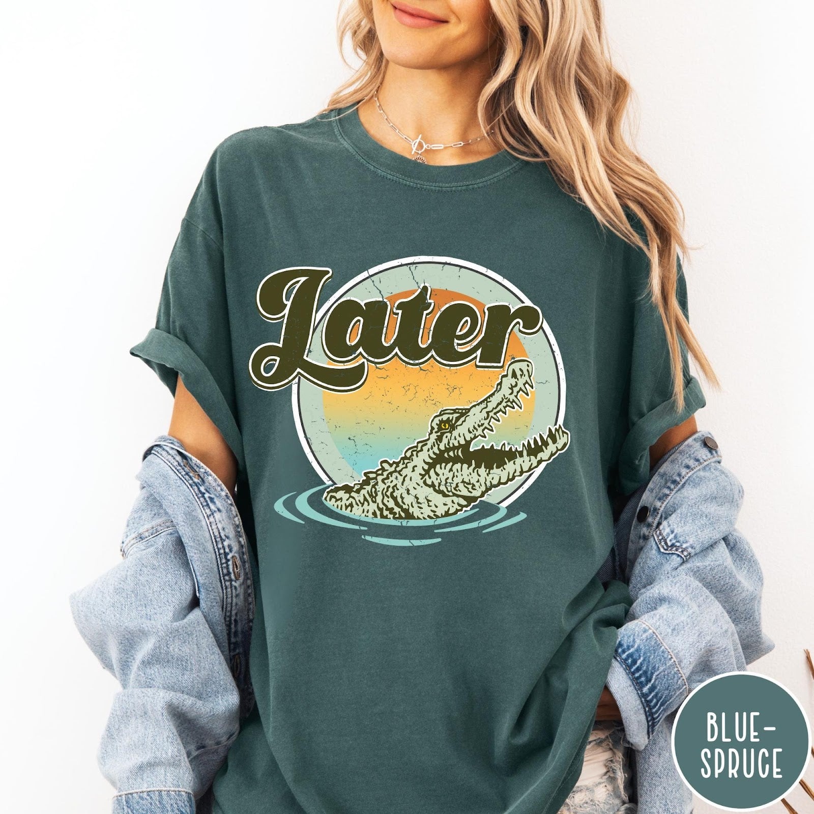 Comfort Colors tee in Blue Spruce featuring vintage style graphic of an alligator emerging from water with sunset background