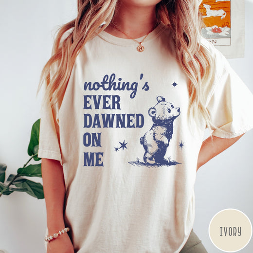 Comfort Colors tee in Ivory featuring illustrated style graphic of a small bear looking up at stars