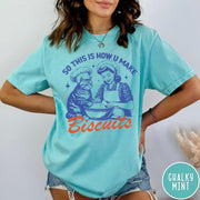 Comfort Colors tee in Chalky Mint featuring vintage style graphic of a woman and cat baking biscuits together