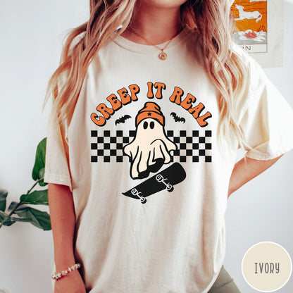 Comfort Colors tee in Ivory featuring retro style ghost graphic with skateboard and checkered background pattern