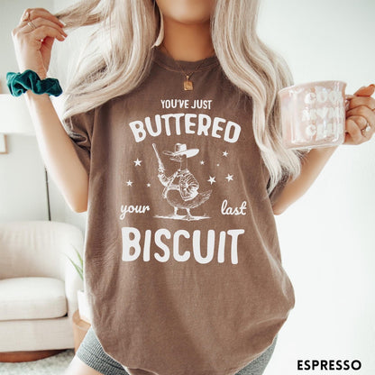 Comfort Colors tee in Espresso featuring western graphic style cowboy goose holding a revolver with star accents
