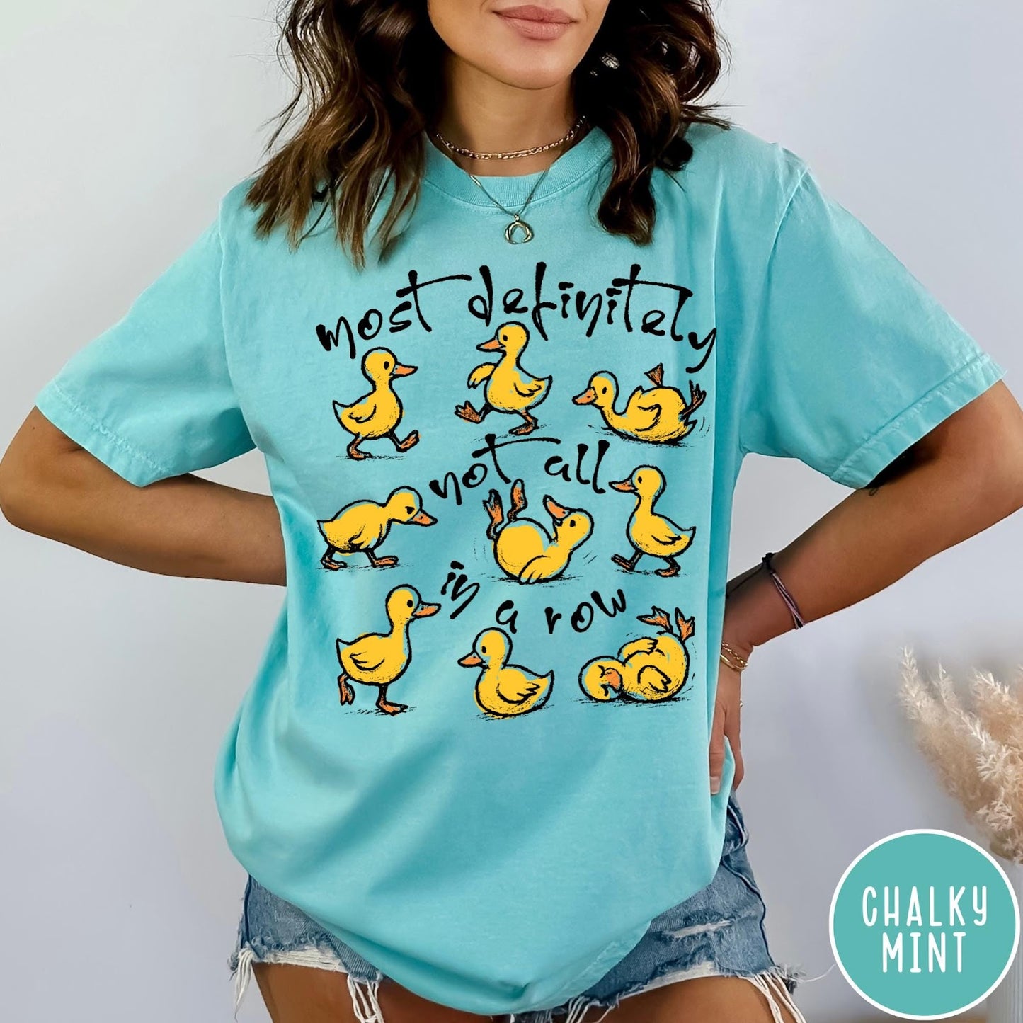 Comfort Colors tee in Chalky Mint featuring screen print style graphic of nine yellow ducks in various poses