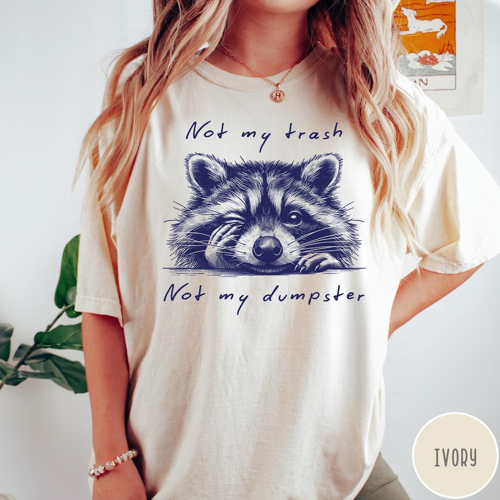 Comfort Colors tee in Ivory featuring illustrated style graphic of a winking raccoon with text not my trash