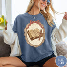 Comfort Colors tee in Blue Jean featuring vintage style graphic of an open Bible and wooden cross