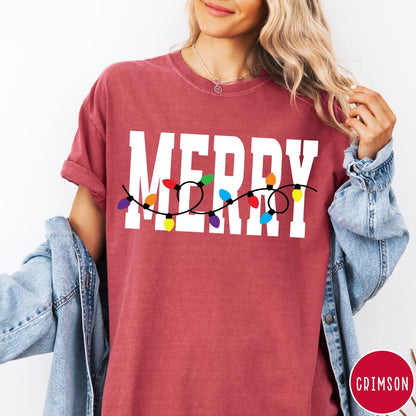 Comfort Colors tee in Crimson featuring holiday style graphic with white Merry text and colorful Christmas lights