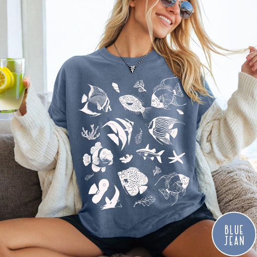 Comfort Colors tee in Blue Jean featuring coastal style graphic with various tropical fish and ocean life illustrations
