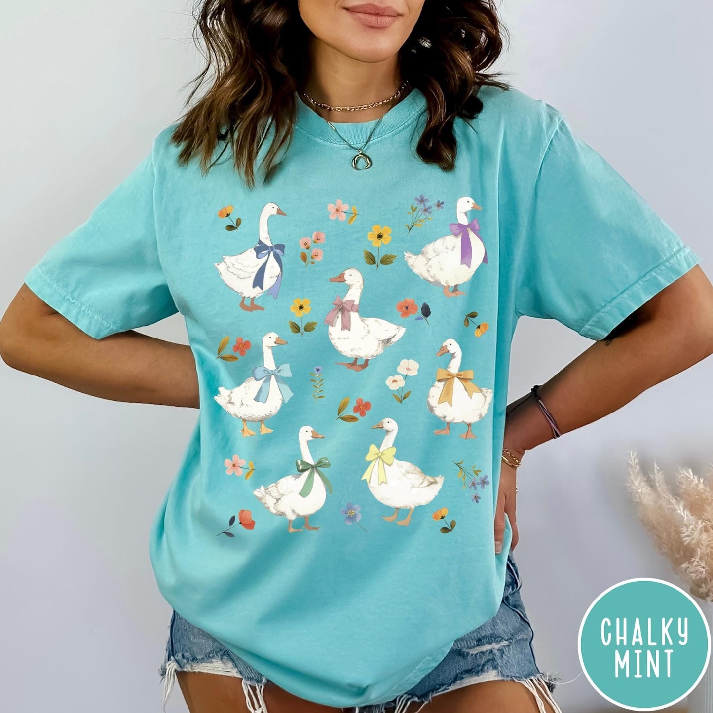 Comfort Colors tee in Chalky Mint featuring vintage style graphic of several white geese wearing colorful bows and flowers