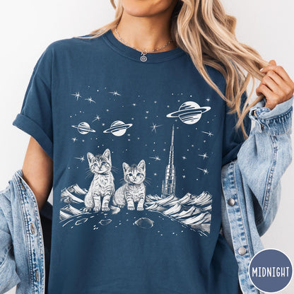 Comfort Colors tee in Midnight featuring line art graphic of two kittens sitting on a planet with rocket