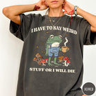 Comfort Colors tee in Pepper featuring illustrative frog graphic with coffee cup and various forest mushrooms