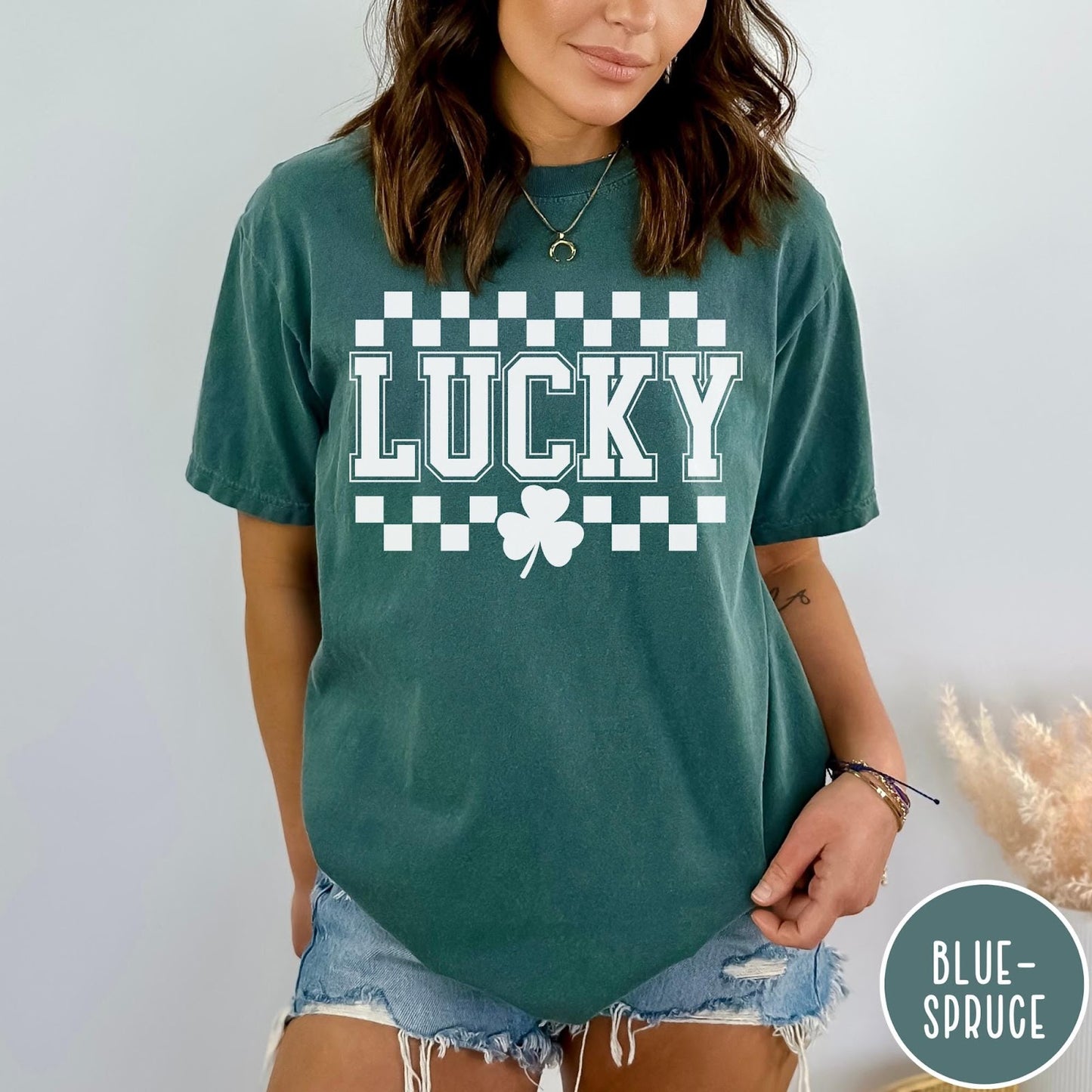 Comfort Colors tee in Blue Spruce featuring checkerboard design with Lucky text and a shamrock graphic