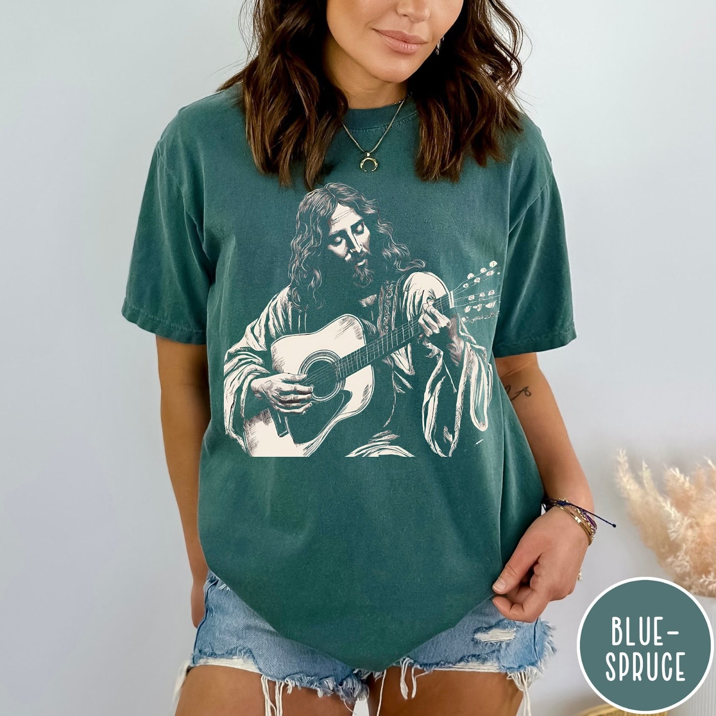 Comfort Colors tee in Blue Spruce featuring vintage style graphic of Jesus playing an acoustic guitar