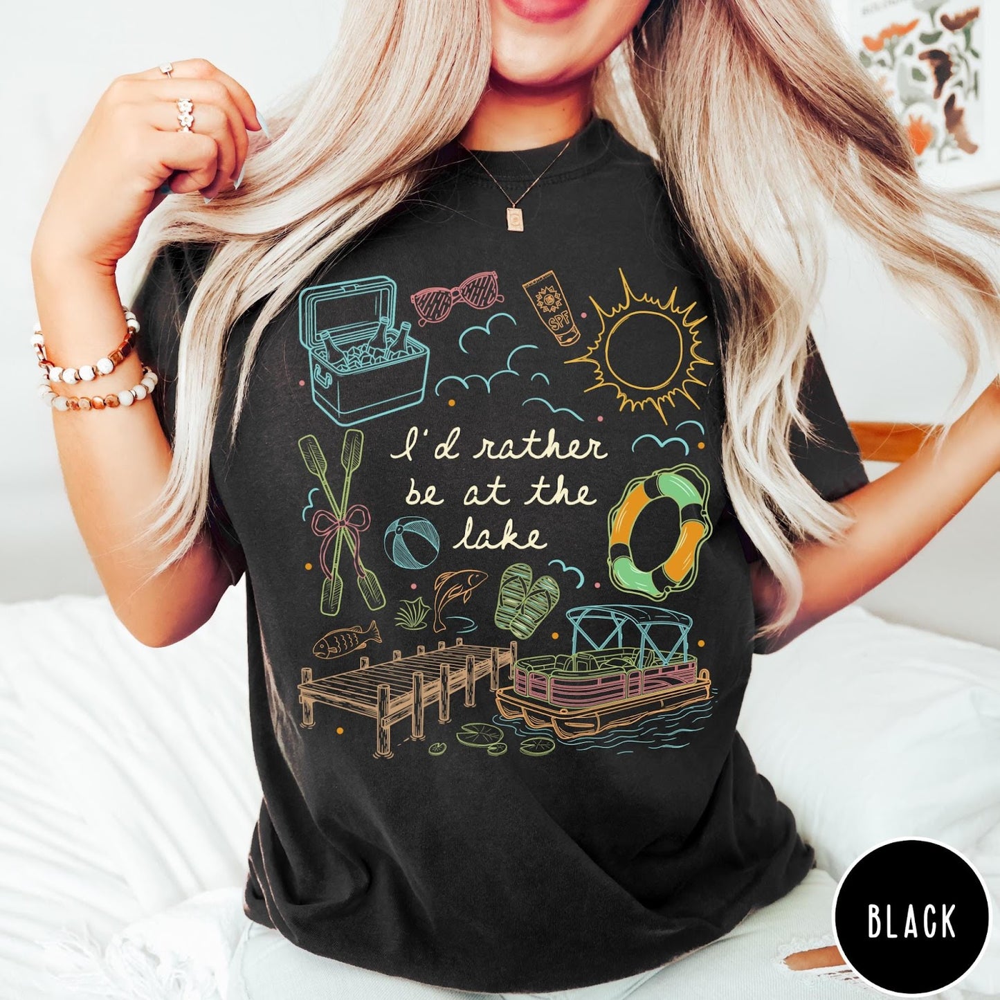 Comfort Colors tee in Black featuring lake vacation graphic with pontoon boat, dock, and summer accessories